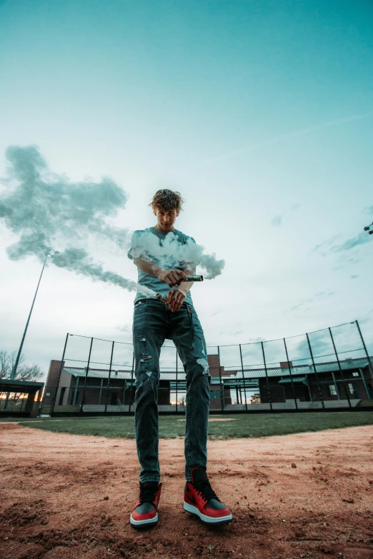 a young man standing on the baseball diamond with his arms crossed