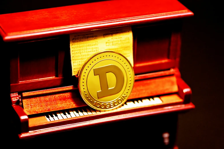 a yellow d coin is sitting on the keys of a red piano