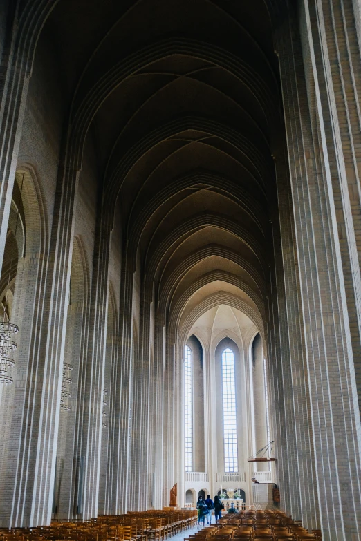 inside of a cathedral filled with wooden pews