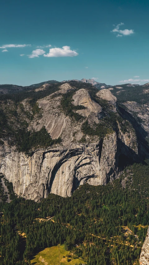 a mountain with trees, hills and a valley