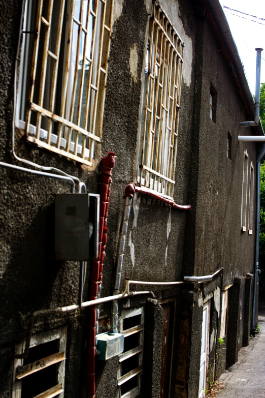 some rusty metal windows and barred windows in front of a building