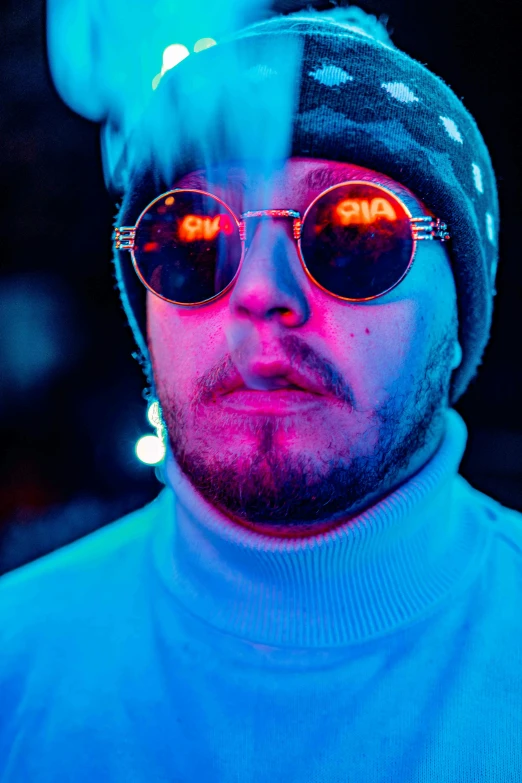 a man wearing sunglasses and a hat smoking