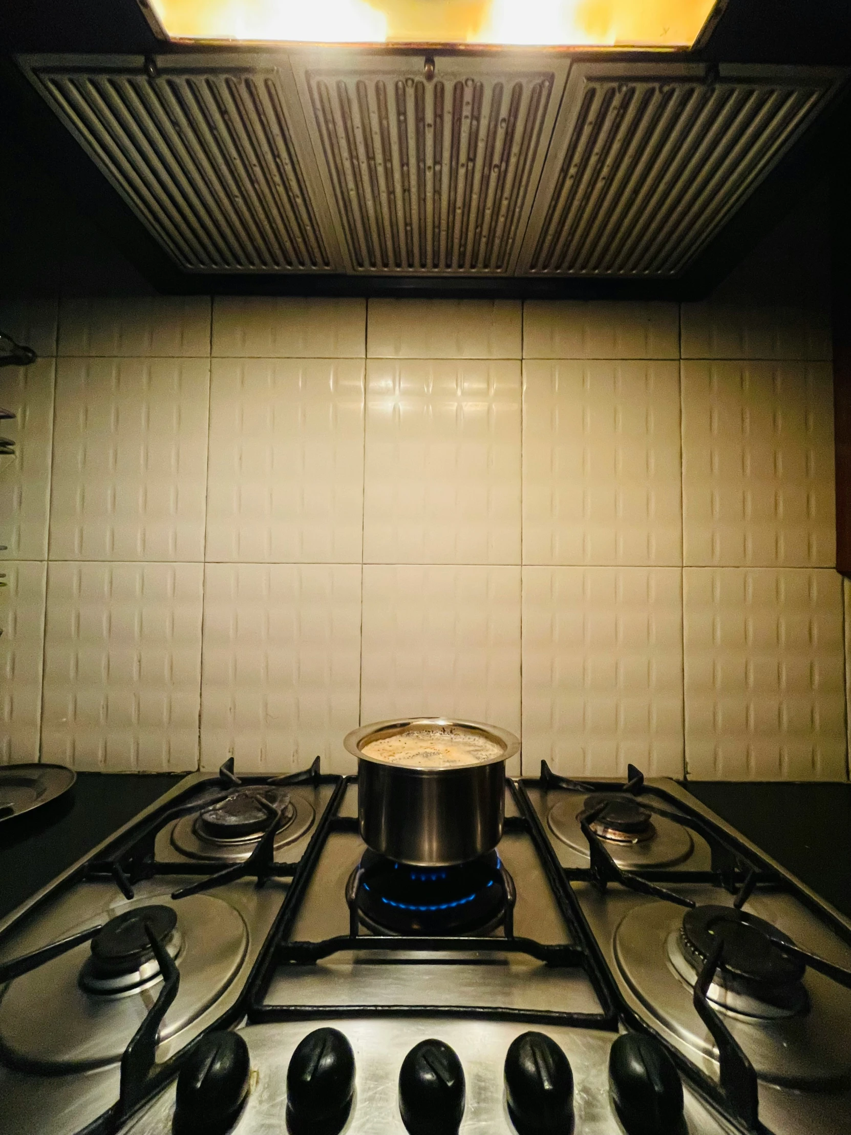 a gas stove top in a kitchen under a microwave