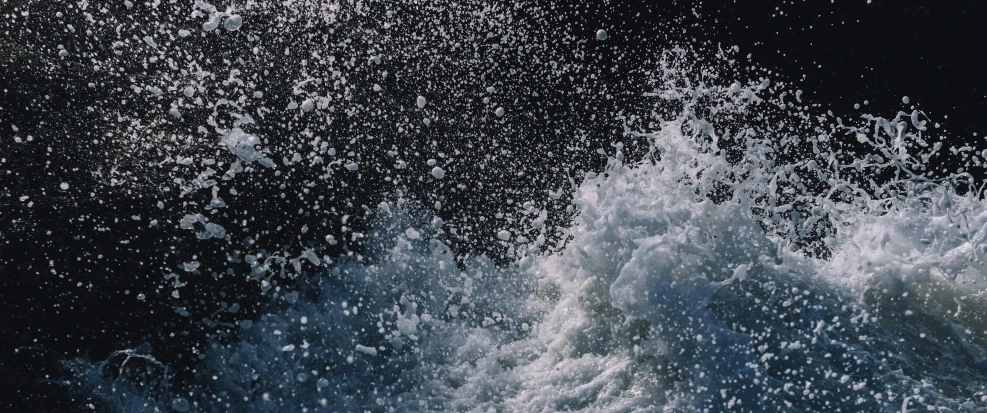 an ocean wave hitting the beach on a sunny day