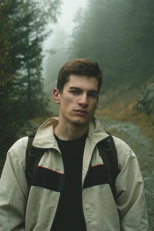 a man stands on a dirt trail in the fog