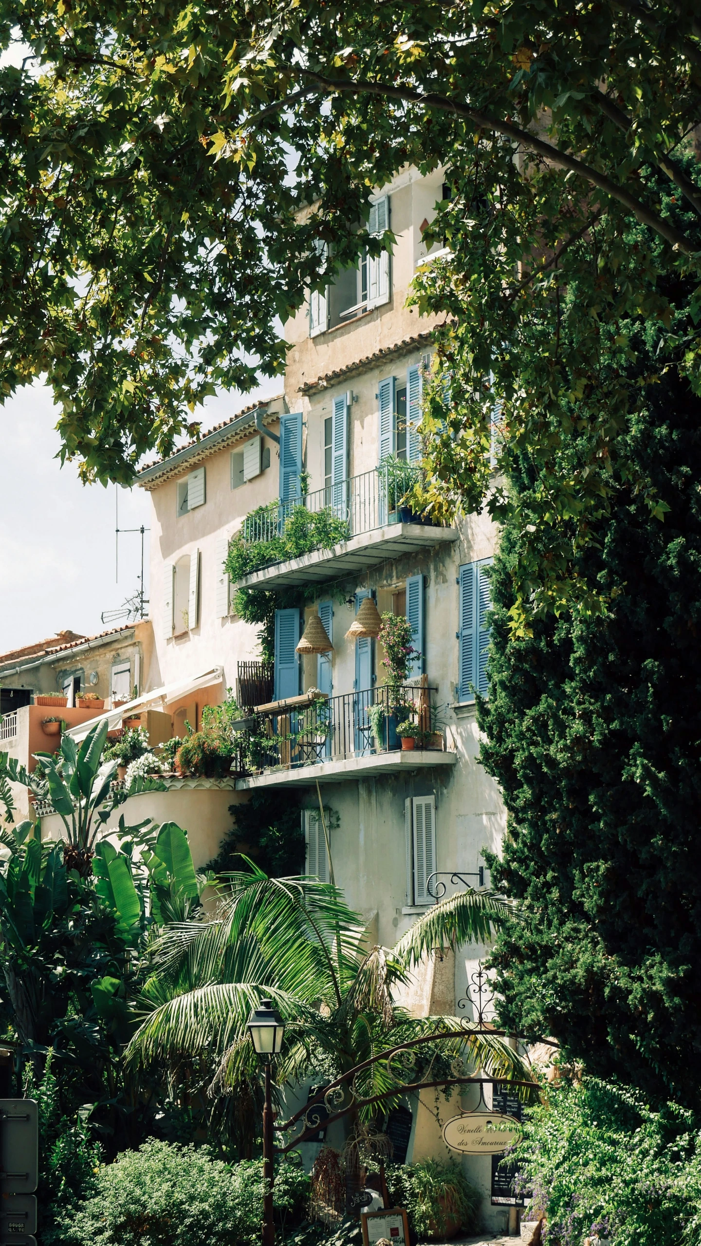 building in the middle of some trees with open shutters