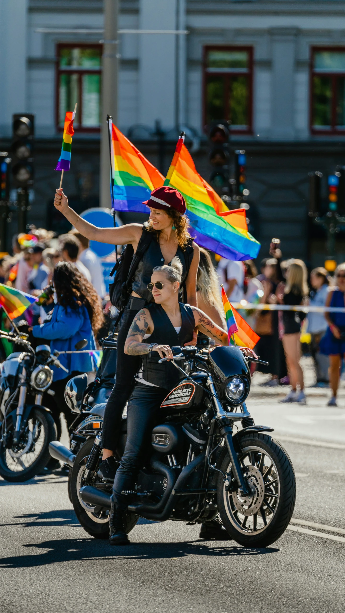 two girls are on motorcycle carrying a flag and looking at the camera