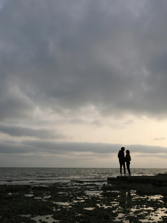 a man and a woman on the beach are emcing