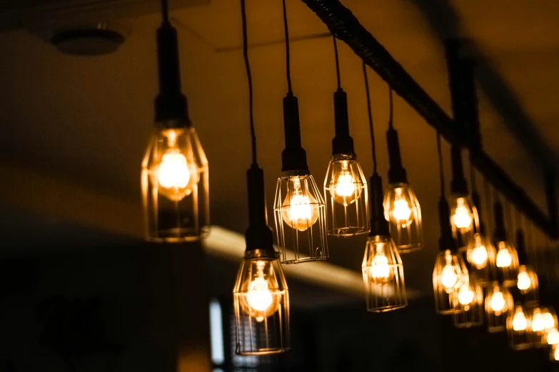 several lit up bulb lights hanging from a ceiling