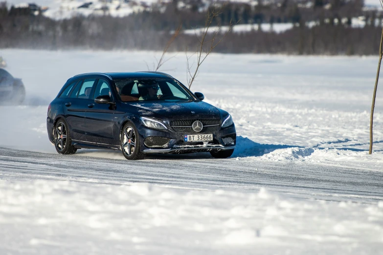 blue mercedes car with black wheels driving in snow