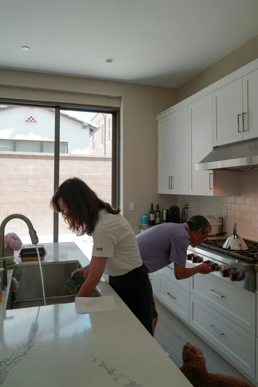 two women are doing soing in the kitchen