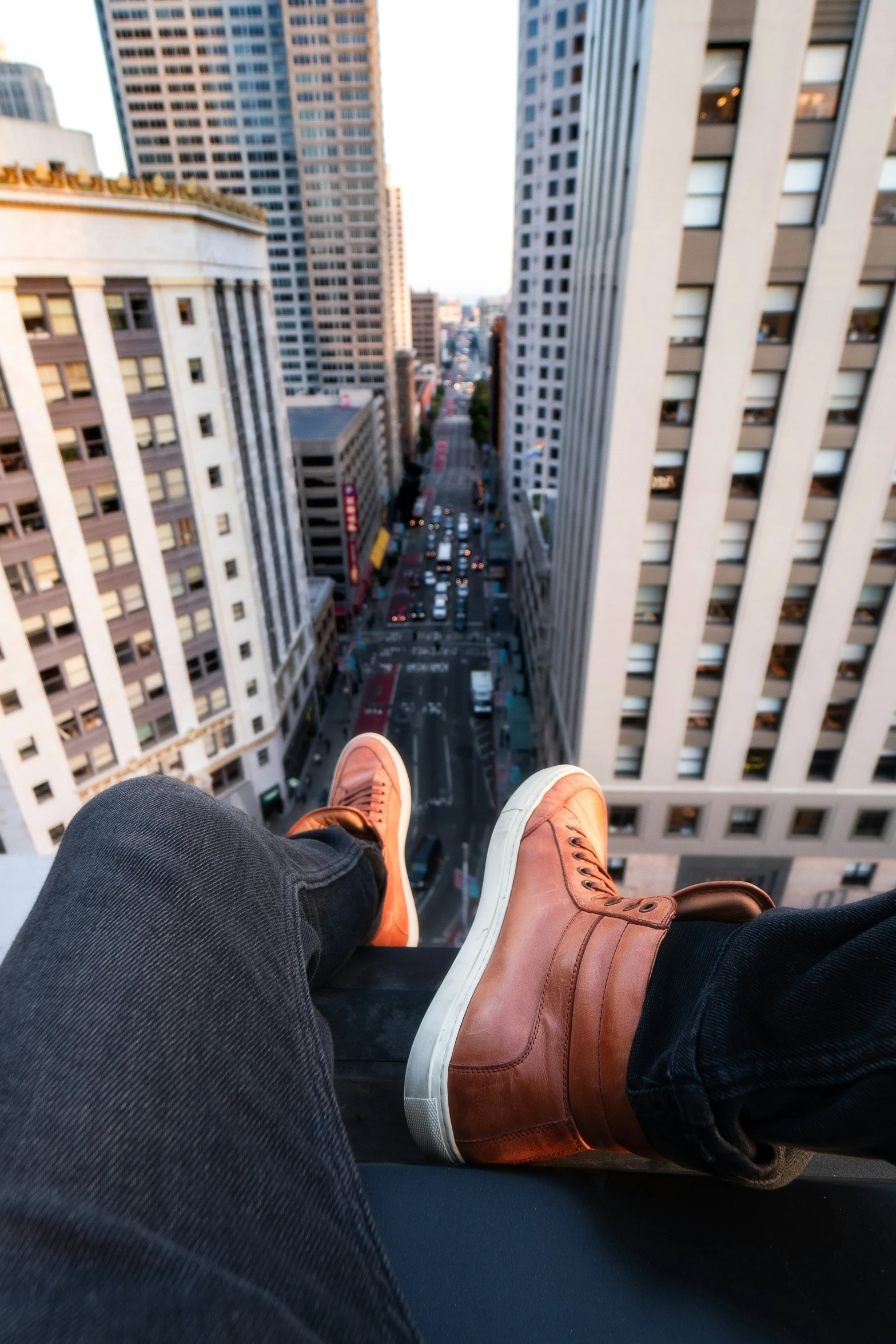 person's feet resting on top of a roof, with skyscrs in the background