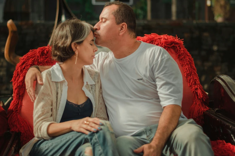 a man and woman kissing and sitting together