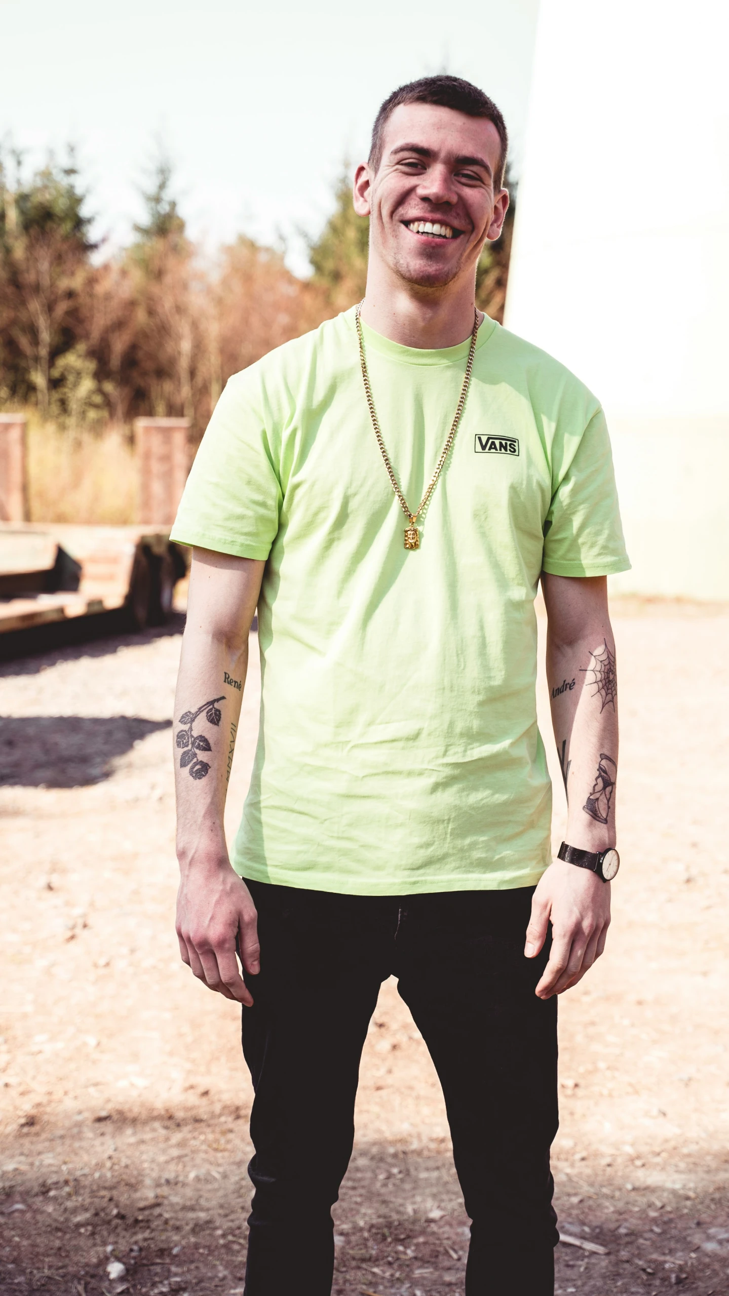 a man with tattoos in a yellow shirt posing for a po