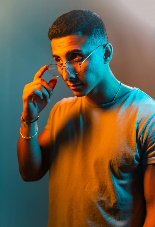 man in glasses standing in front of a blue and yellow backdrop