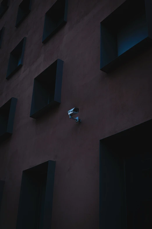 a small white object in a wall next to many black boxes