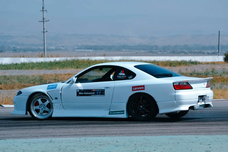 the white sports car is parked in a parking lot