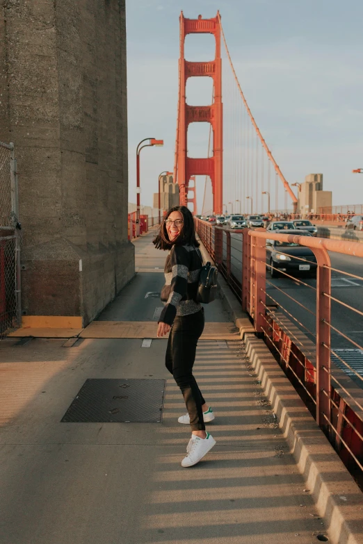 a woman runs down a road near the golden gate bridge