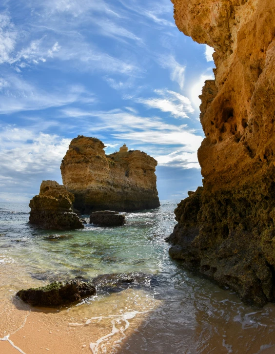 the view of a beach from the inside an ocean cave