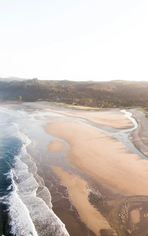 a beach and water view from above during sunrise
