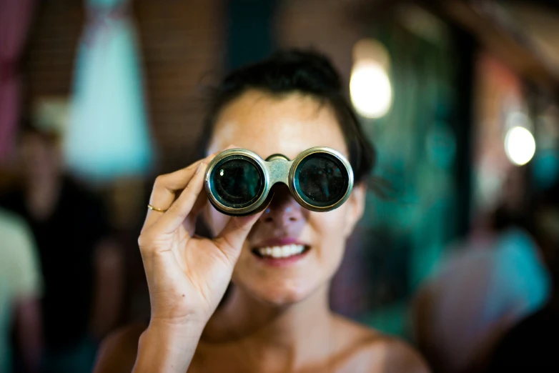 a woman looking through binoculars with her eye