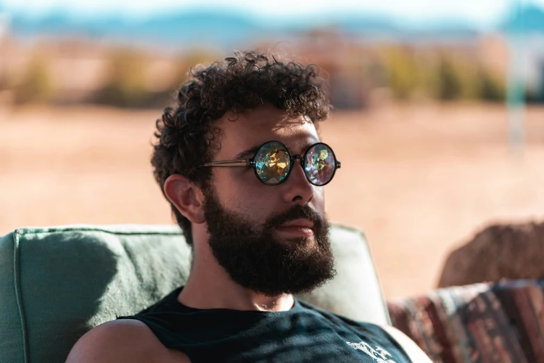 a man in glasses resting on an outdoor sofa