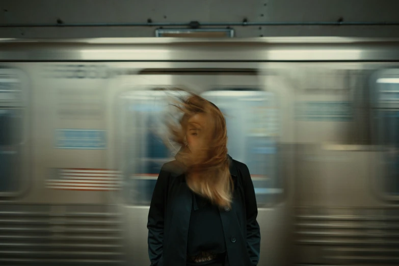 woman with long hair standing near train tracks