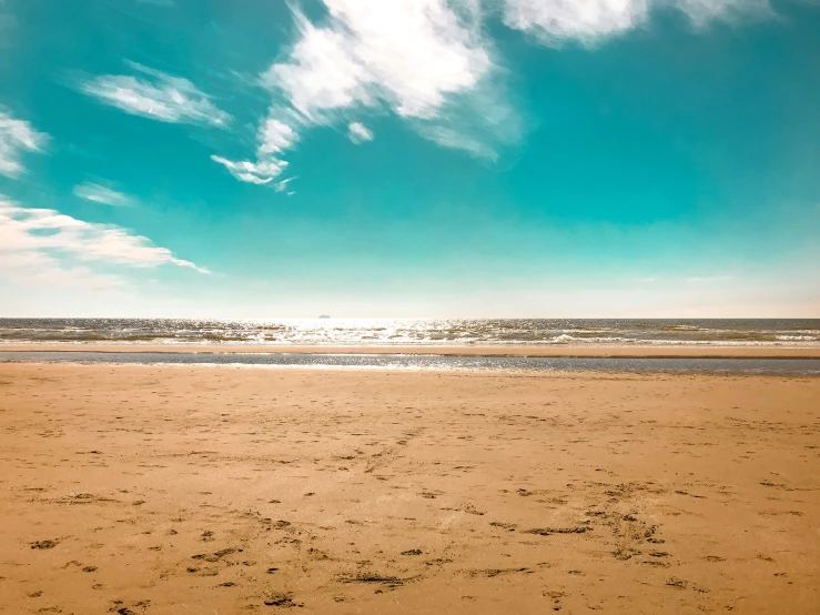 a lone surfboard is in the sand next to the beach