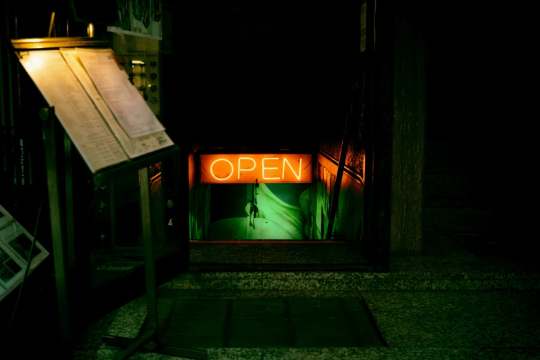 sign for open lit in a doorway at night
