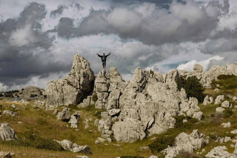 a man on top of a rocky mountain in the sky