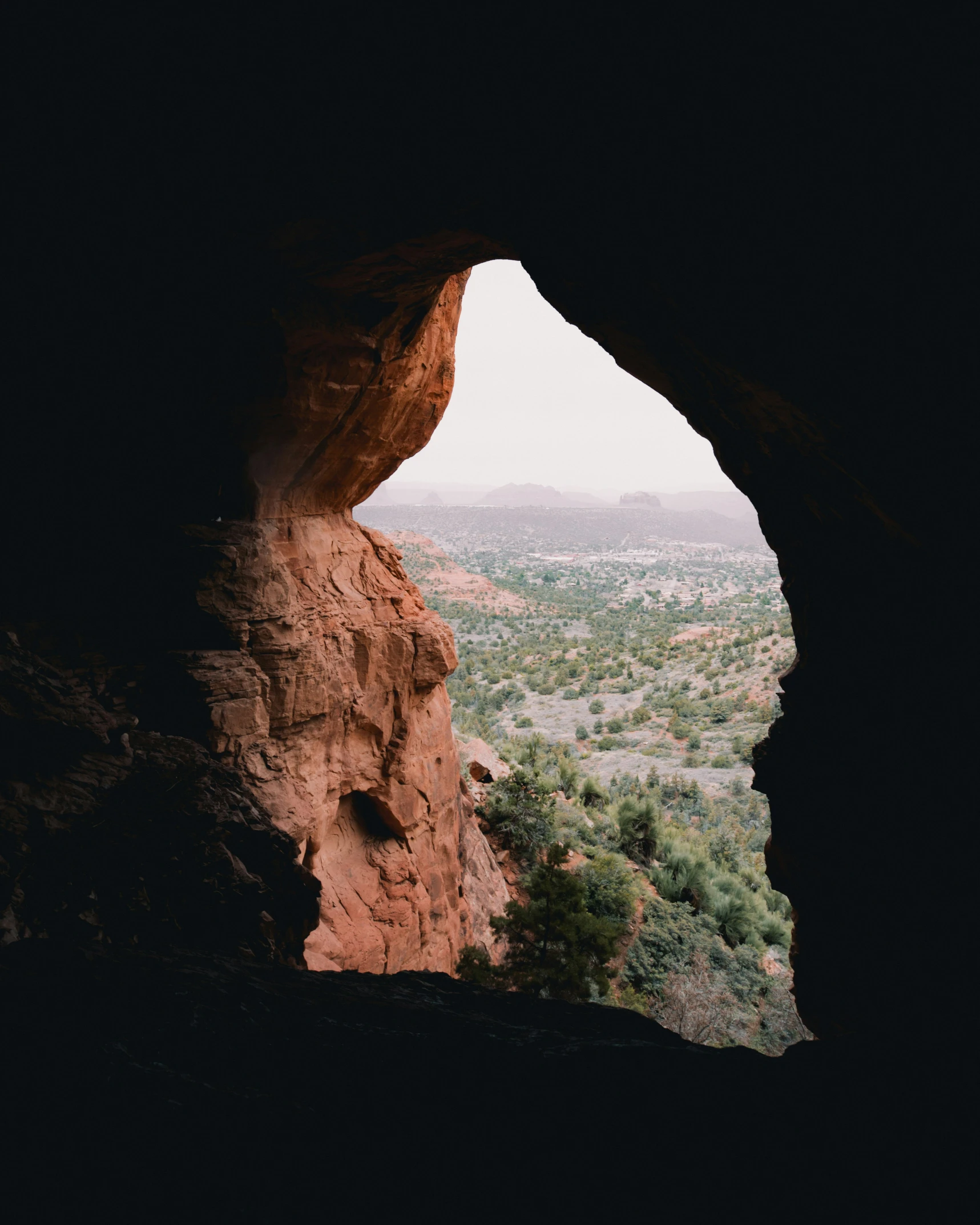 a view out an archway in a cliff