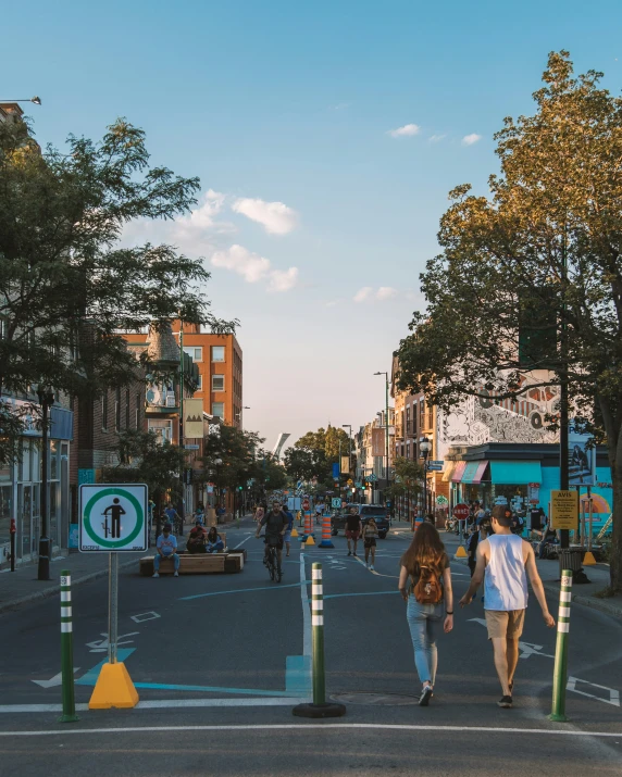 two people cross an intersection while people on bicycles watch