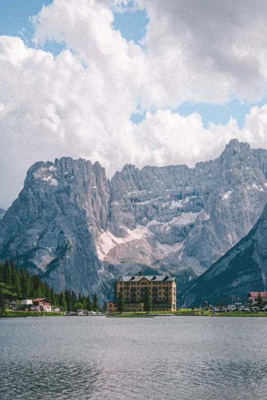 an alpine mountain scene, with water and buildings