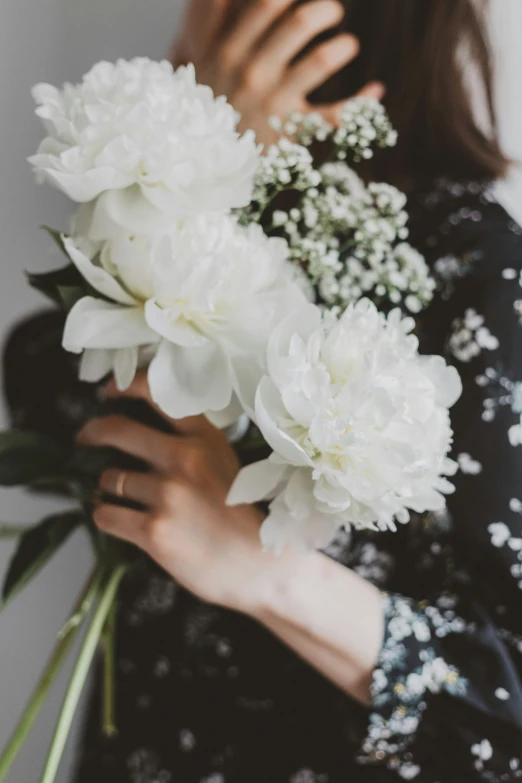 a woman holding a bouquet of white flowers