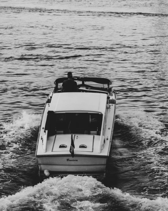 an old boat going on the water and a man standing on it