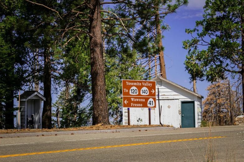 a road with a sign on it next to a small shack