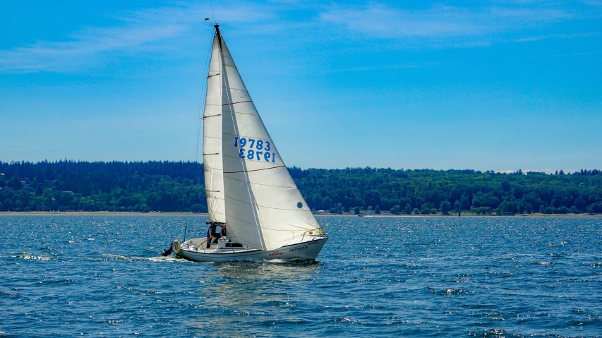 sailboat on the ocean with mountains in the distance