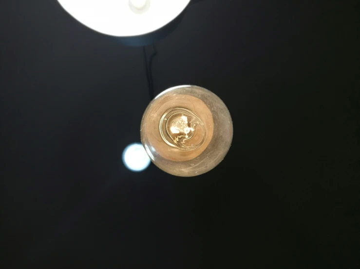 a small light hanging from a metal object in a dark room