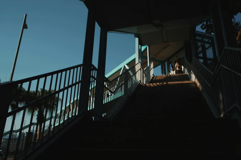 a couple standing on the top of a staircase next to each other