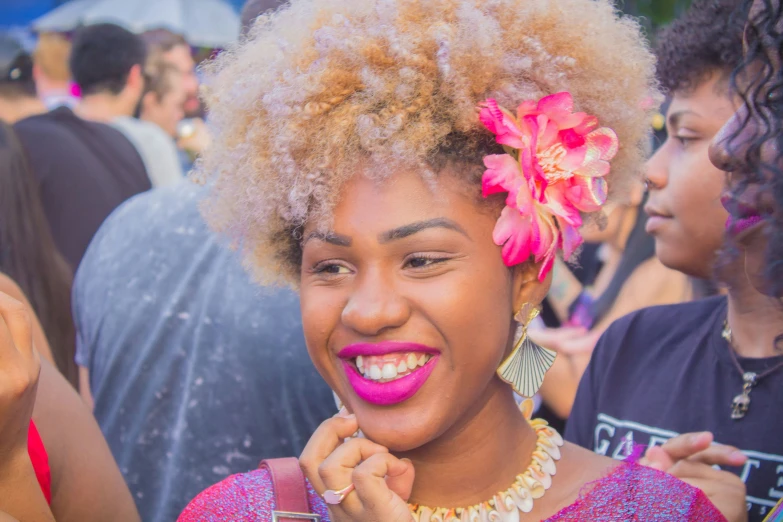a woman with a pink flower in her hair is posing for the camera