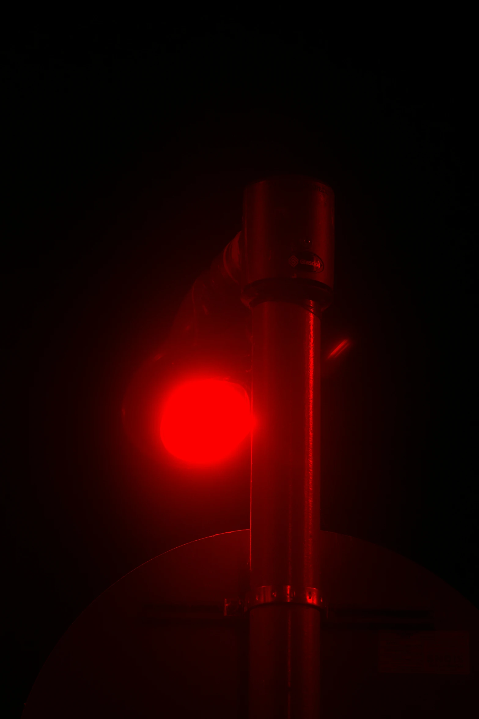 a red stop light at night on the pole