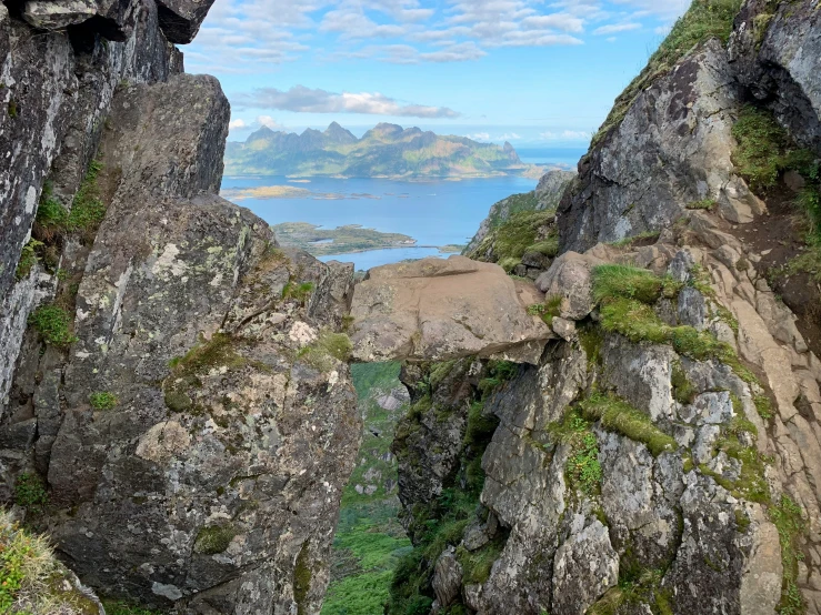 some big mountains and rocks with water in the background