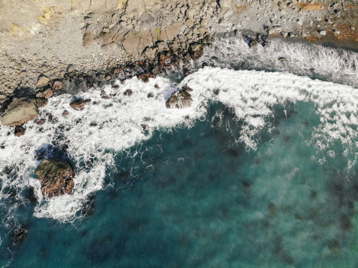 the aerial view of the sea and rocky coastline