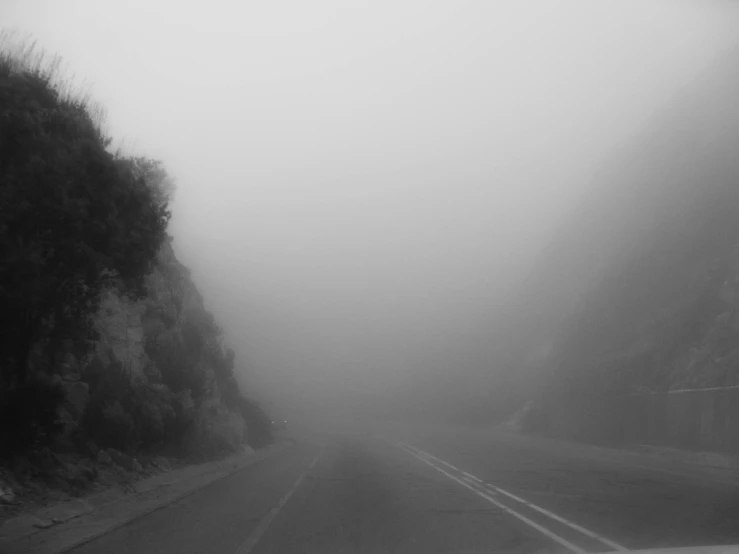 view from inside a car looking at the road with fog