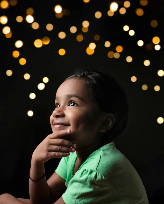 a  poses for a portrait against gold and white bokeh