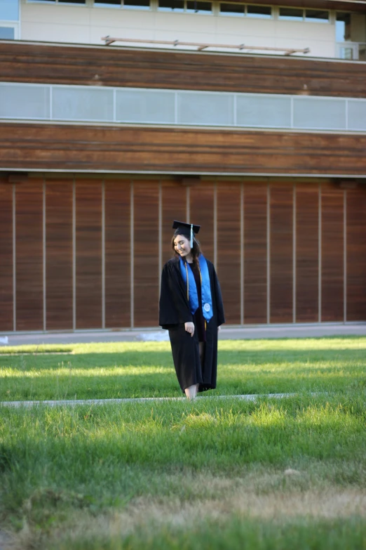 two people stand on a grassy field in front of a building