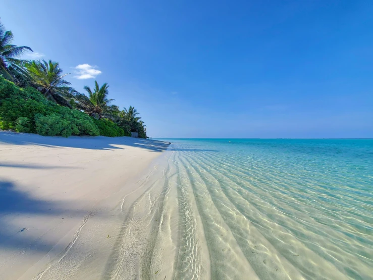 a beach with white sand and clear blue water