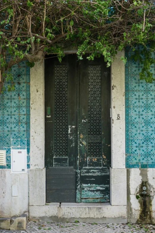 a doorway that is in front of a building with blue tiles on it