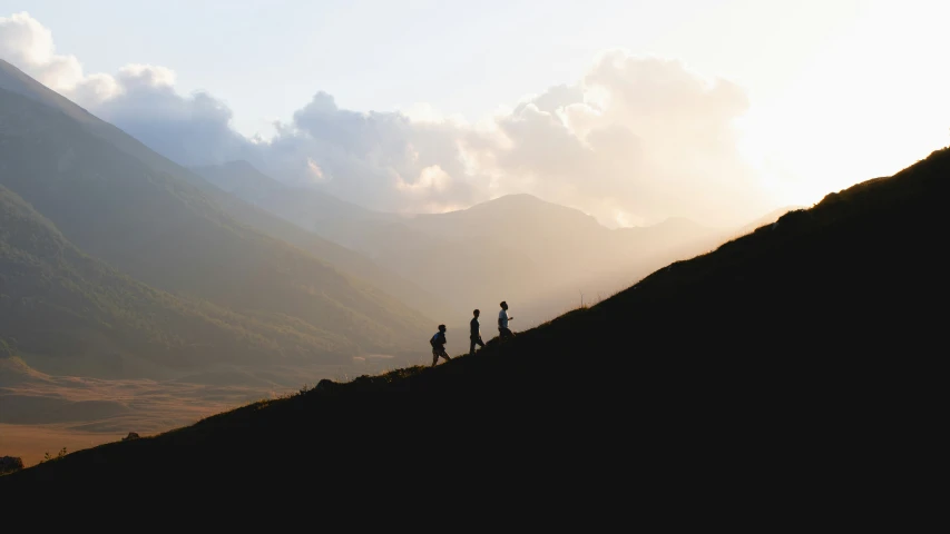 four people are standing on the top of the hill