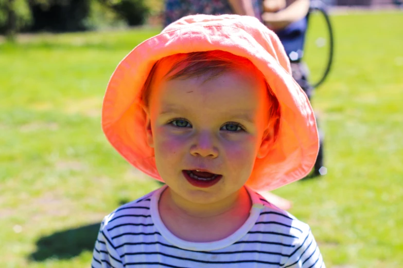 a little girl with a big orange hat on